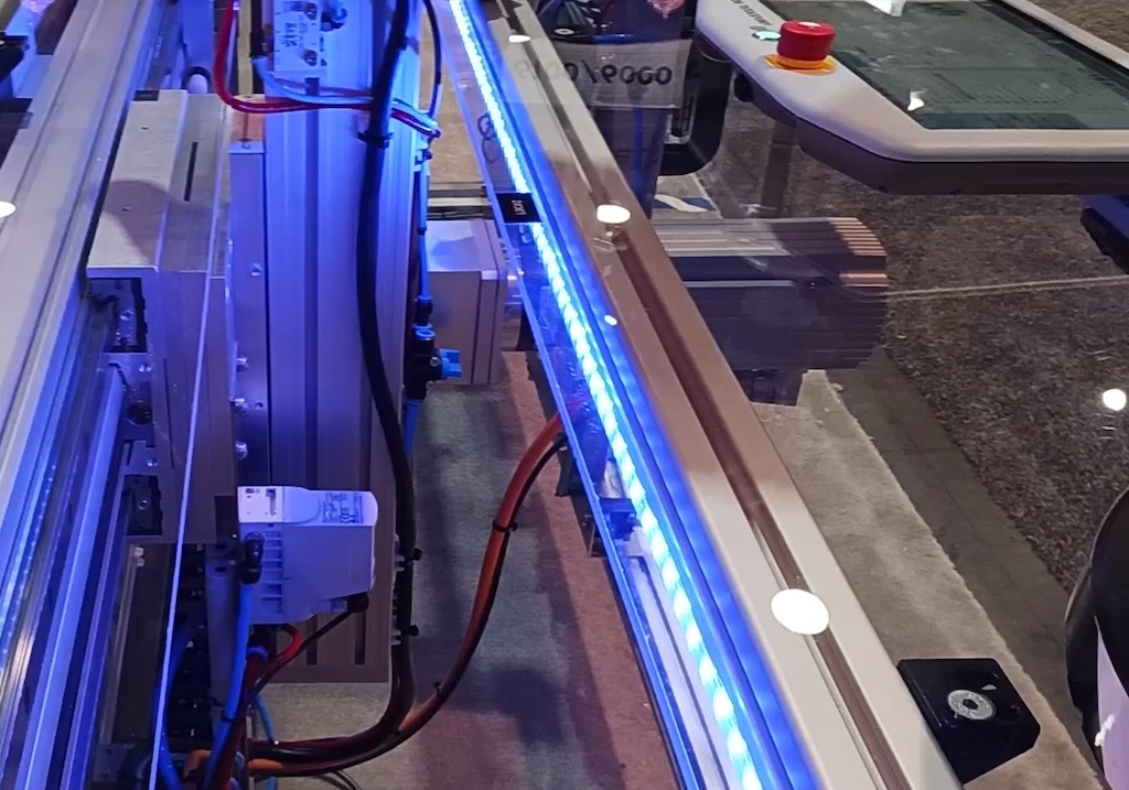 The linear guide on the left adds an axis of mobility to the attached UR5 robot from Universal Robots (see other photo). This design can handle up to a UR20 size, and the Universal Robots software (see teach pendant, top right) integrates the extra axis as its own, as demonstrated at the Festo Corp. booth at Pack Expo Las Vegas 2023. Courtesy: Mark T. Hoske, Control Engineering
