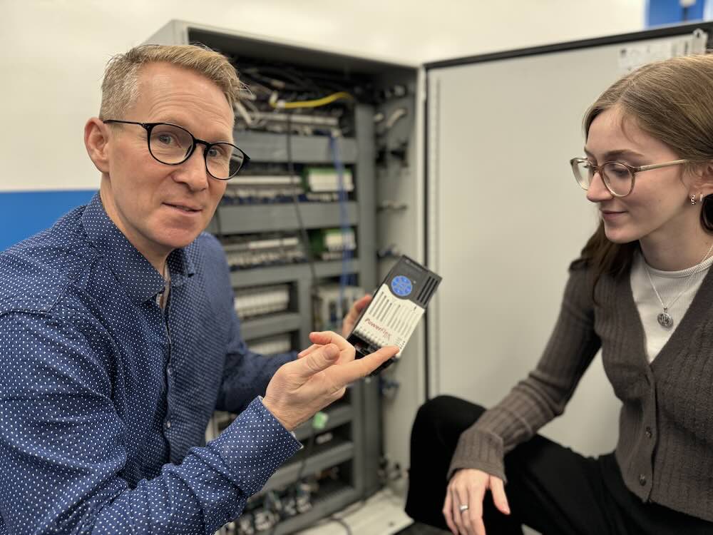 Michael Wrinch, with engineer Alia Gola, holding the Allen-Bradley PowerFlex AC Motor Drive from Rockwell automation, to be installed in the panel behind them. Courtesy: Hedgehog Technologies