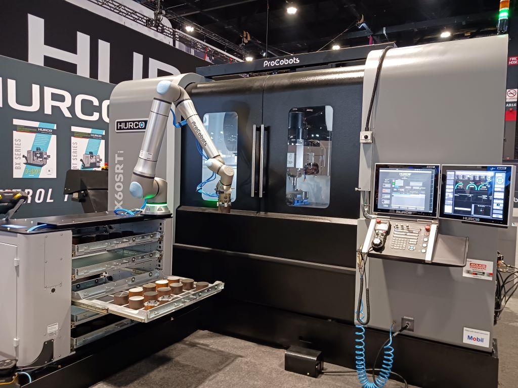 A Hurco CNC machine is tended by a UR20 cobot, UR’s longest-reach cobot; the machine-tending system integrates the Universal Robots UR20, a collaborative auto door, grippers and pneumatic vises, as seen at the Hurco IMTS 2024 booth. Courtesy: Mark T. Hoske, WTWH Media